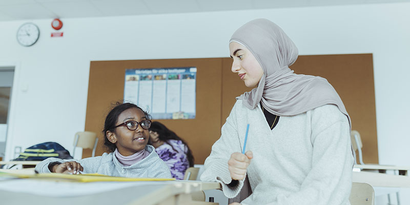 Läraren Nadin El-Machharawi hjälper eleven Amiira under lovskolan på Byttorpsskolan i Borås. Foto: Jeffrey McIntosh